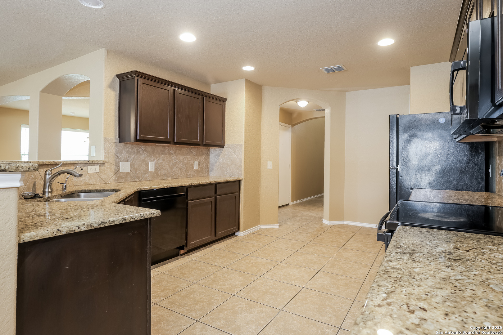 3415 Dunlap Fields Converse, TX 78109 - Photo 6 of 17 a kitchen with kitchen island granite countertop a sink appliances and cabinets