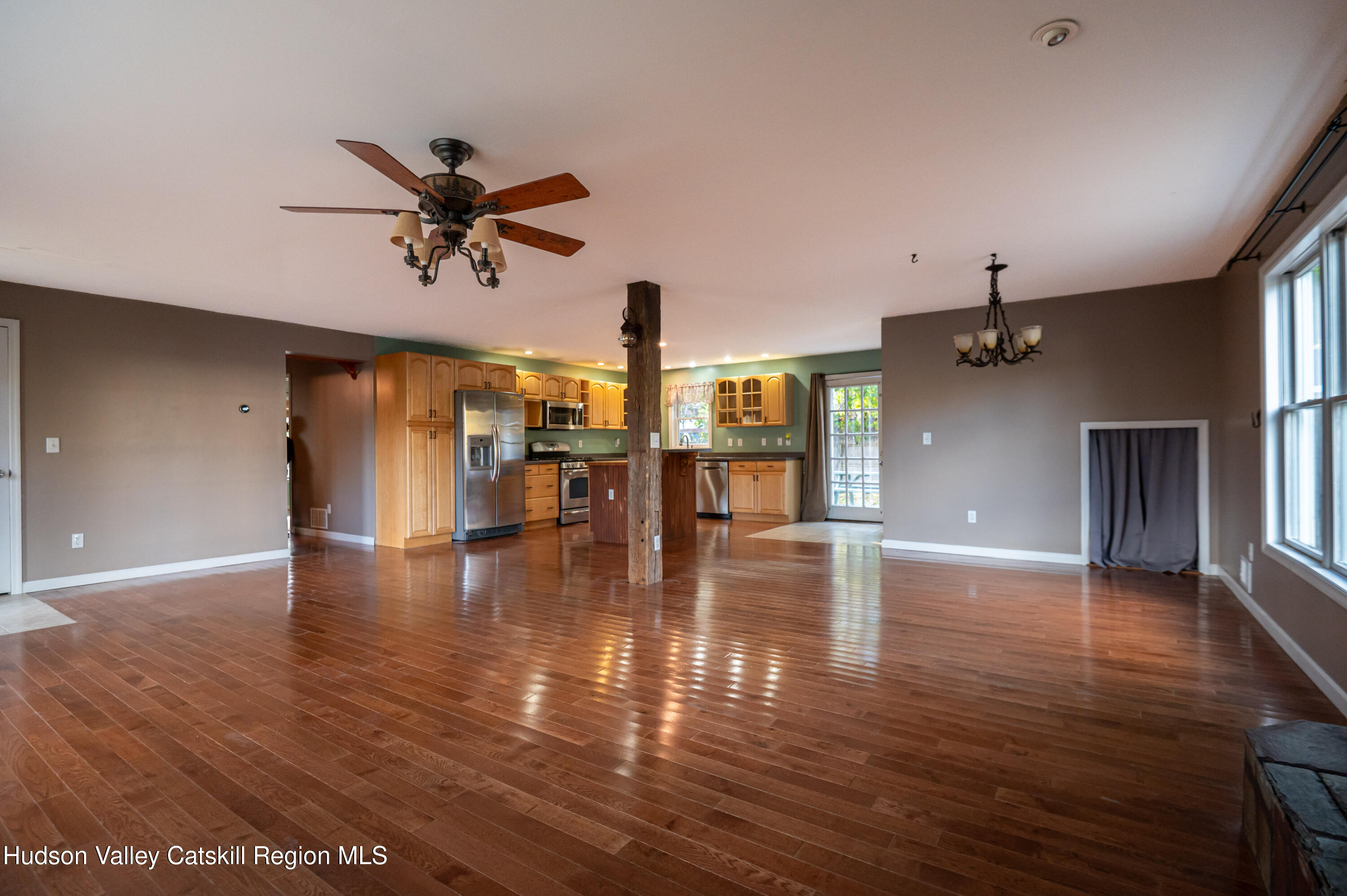 59 Hawley Road Niverville, NY 12130 - Photo 4 of 20 a view of a room with wooden floor a ceiling fan and windows