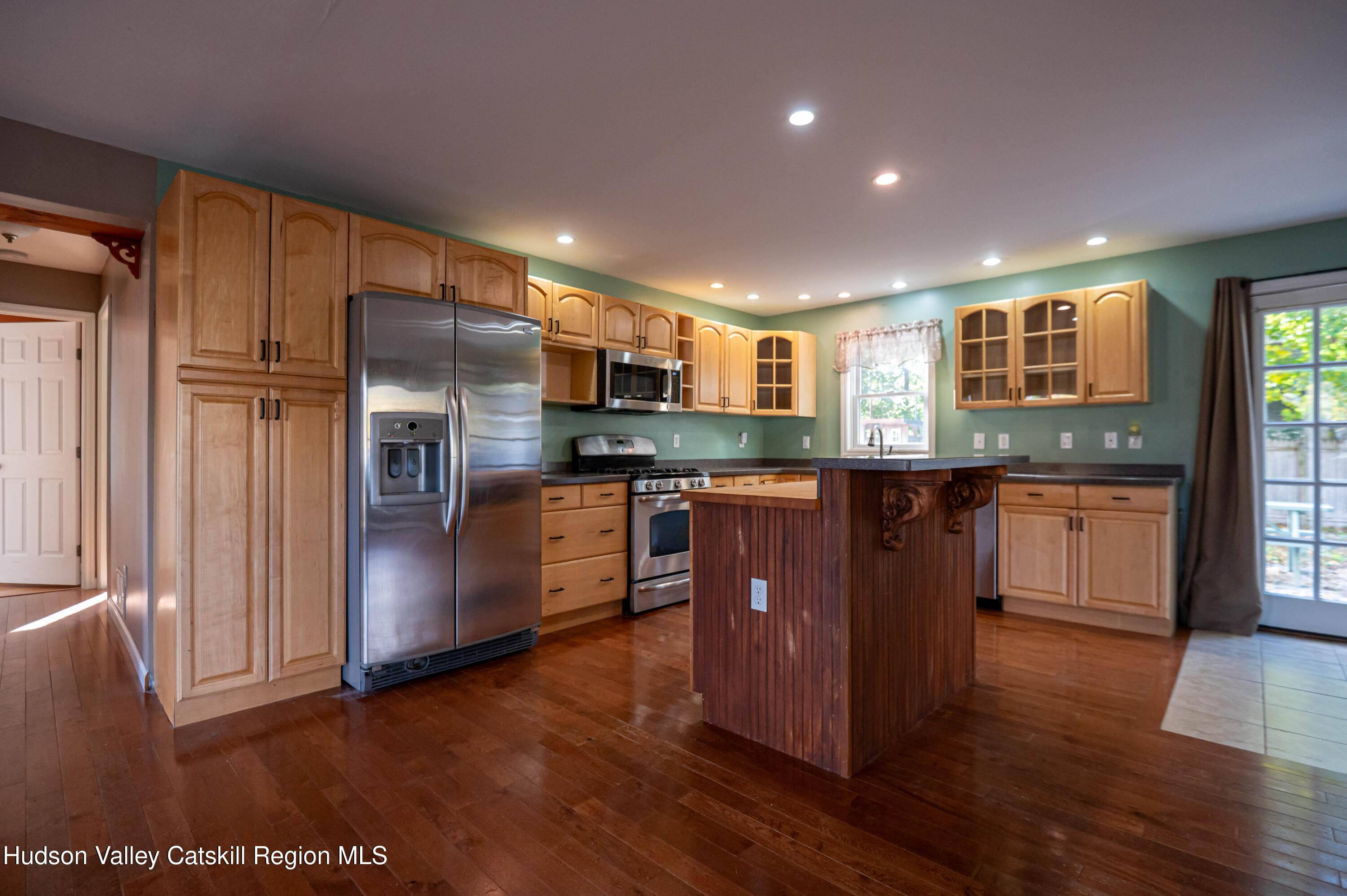 59 Hawley Road Niverville, NY 12130 - Photo 5 of 20 a kitchen with kitchen island granite countertop wooden floors stainless steel appliances a sink and a window
