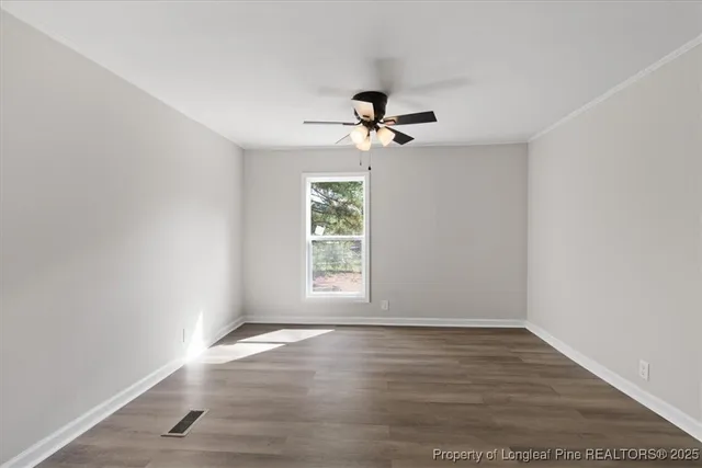 a view of an empty room with wooden floor