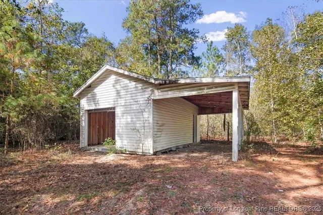 a backyard of a house with barbeque oven and trees