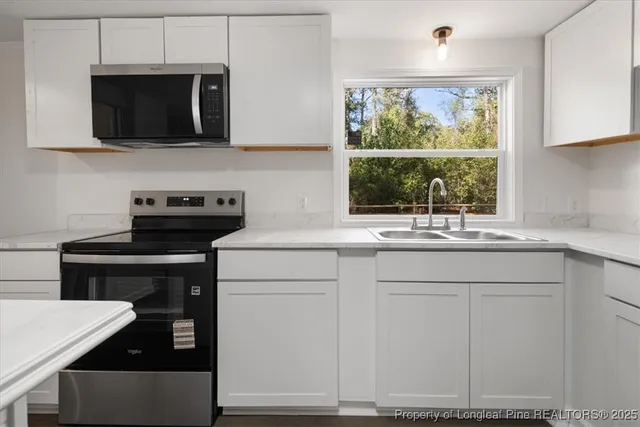 a kitchen with a sink stove and microwave