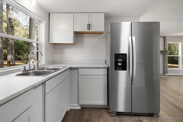 a kitchen with stainless steel appliances a sink cabinets and a window