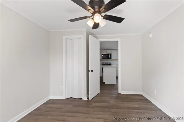 an empty room with wooden floor a ceiling fan and closet