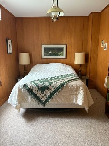 a bedroom with a bed next to a window with walls