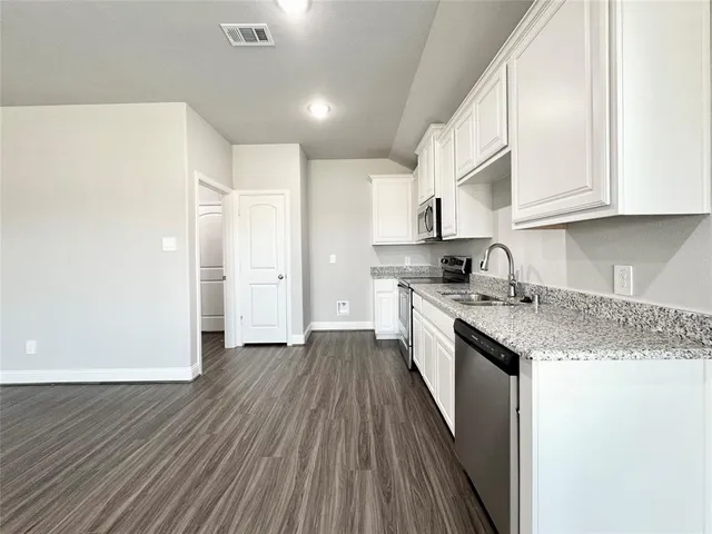 a kitchen with granite countertop a sink and steel appliances