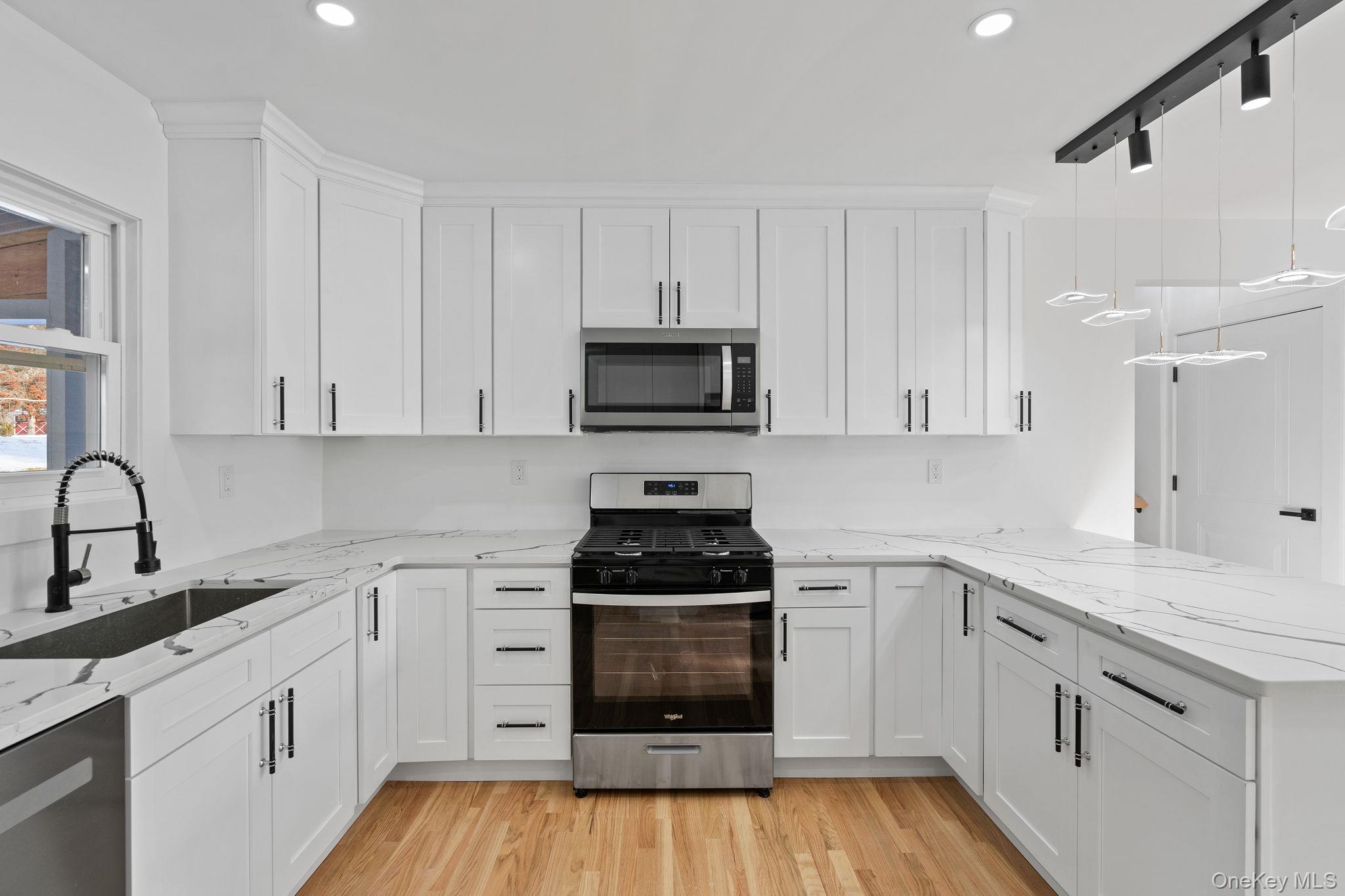 52 Rudolph Road Modena, NY 12548 - Photo 10 of 49 Kitchen with stainless steel appliances, light stone counters, pendant lighting, white cabinetry, and a peninsula