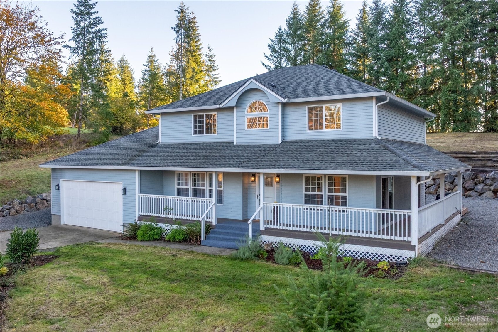 a front view of a house with a yard and trees