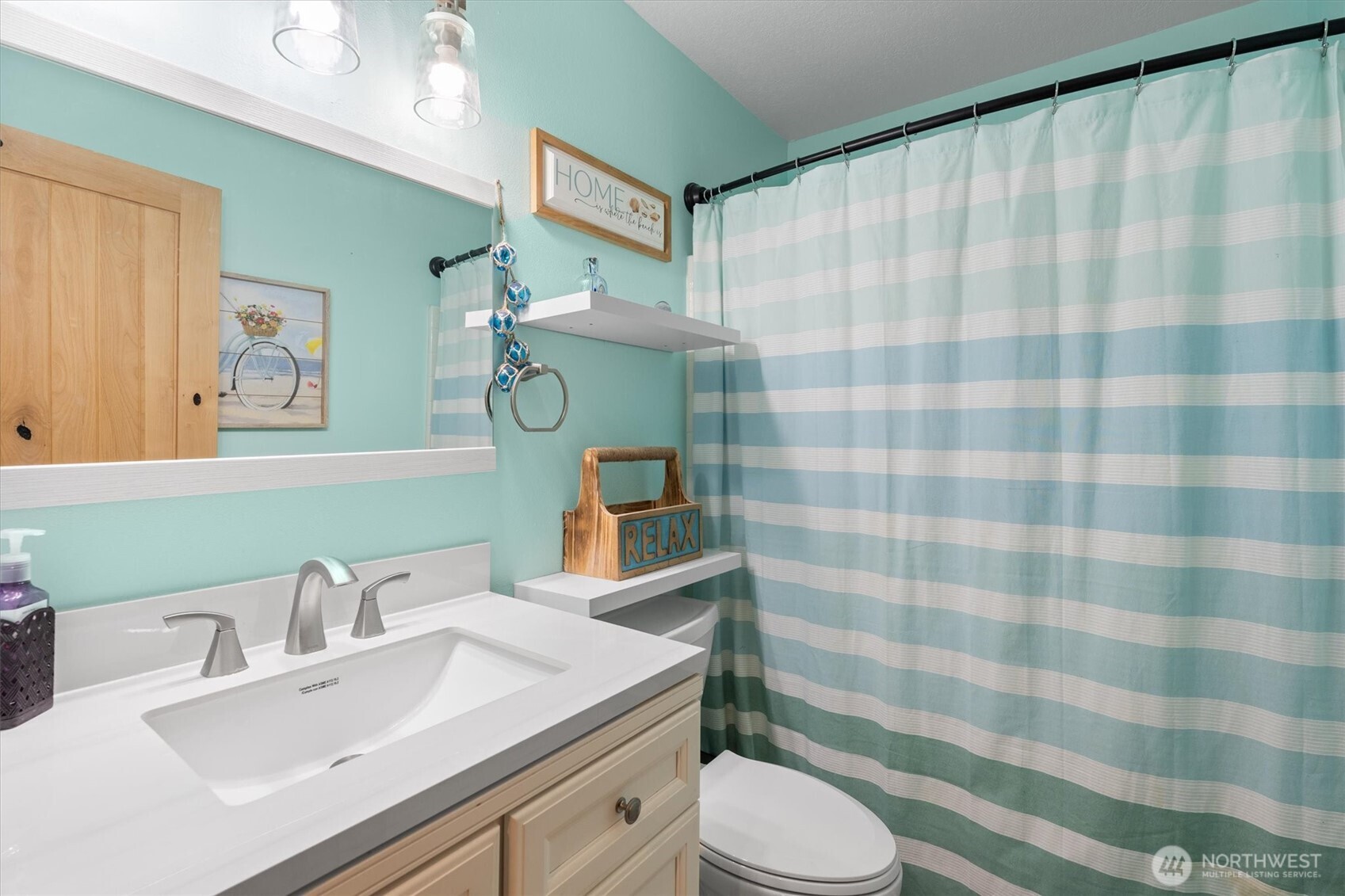 508 Caldwell Road Castle Rock, WA 98611 - Photo 7 of 40 a bathroom with a sink a toilet a mirror and shower curtain