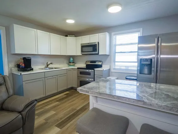 a kitchen with a sink a counter top space cabinets and stainless steel appliances