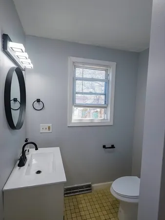 a bathroom with a toilet a sink and a mirror