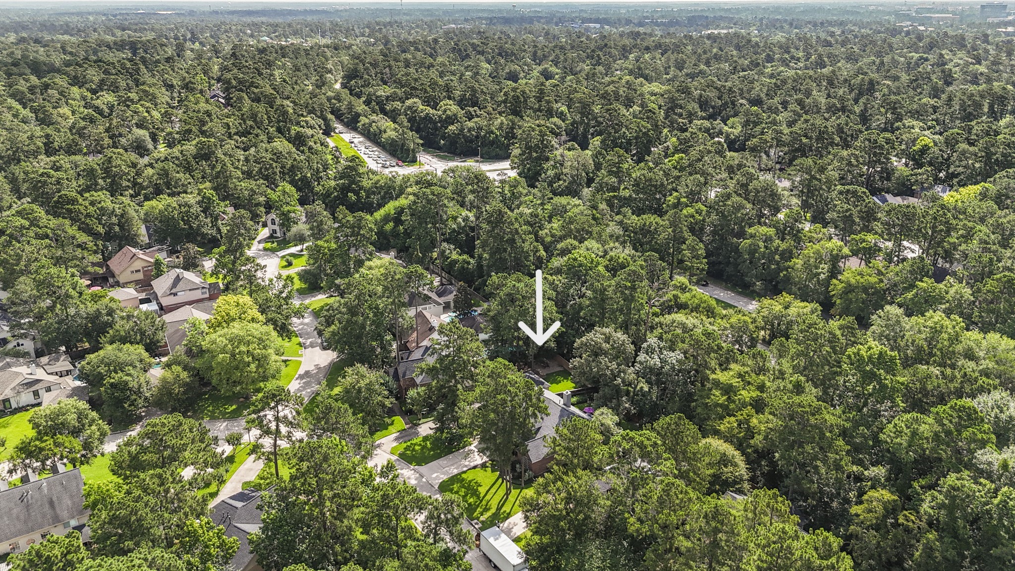 102 Treescape Circle Spring, TX 77381 - Photo 34 of 40 This aerial photo shows a home nestled among lush greenery in a wooded neighborhood. The area appears serene, with well-spaced houses and mature trees providing privacy and a natural setting.