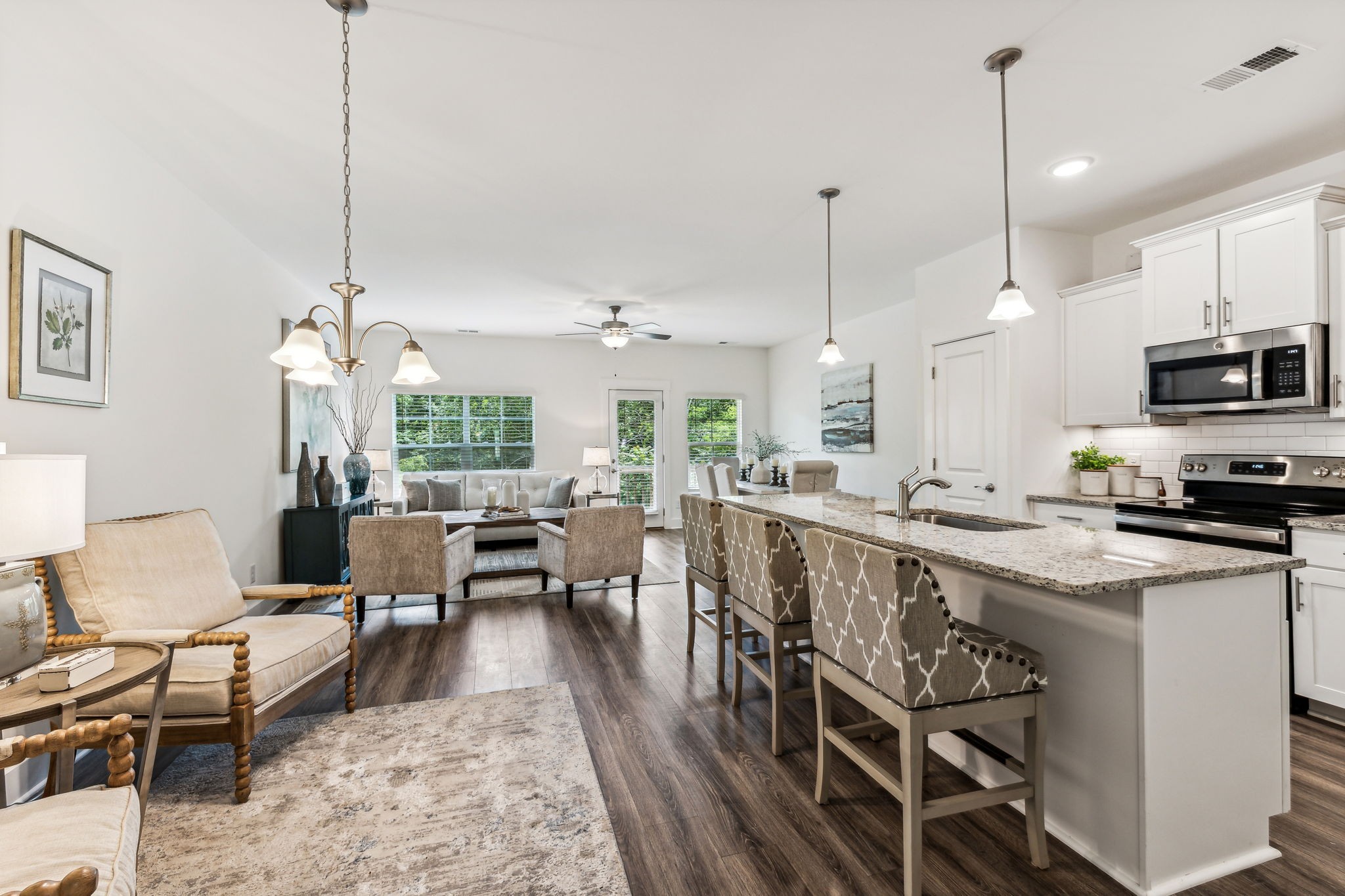 7144 Gracious Drive Franklin, TN 37064 - Photo 5 of 32 a kitchen with kitchen island a dining table chairs a sink and a chandelier