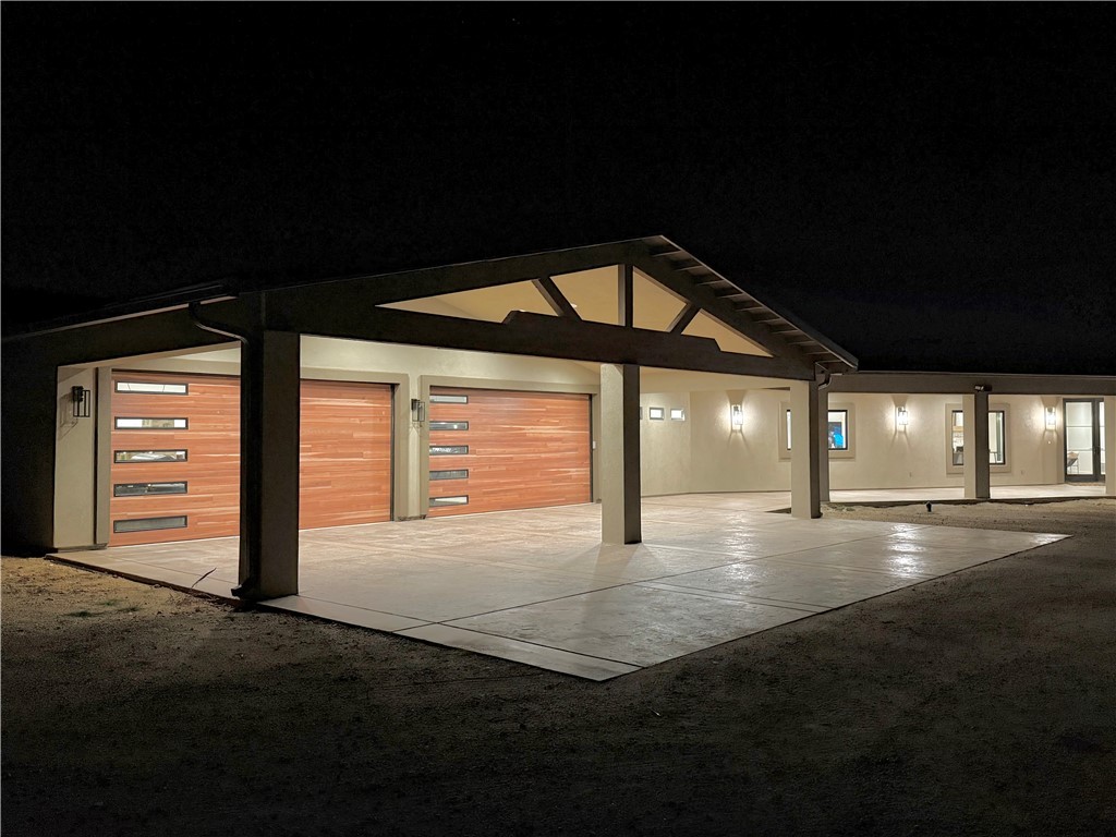 919 West Jordan Ranch Road Kingman, AZ 86409 - Photo 43 of 53 Night time photo showing the gorgeous wood look garage doors and lighting.