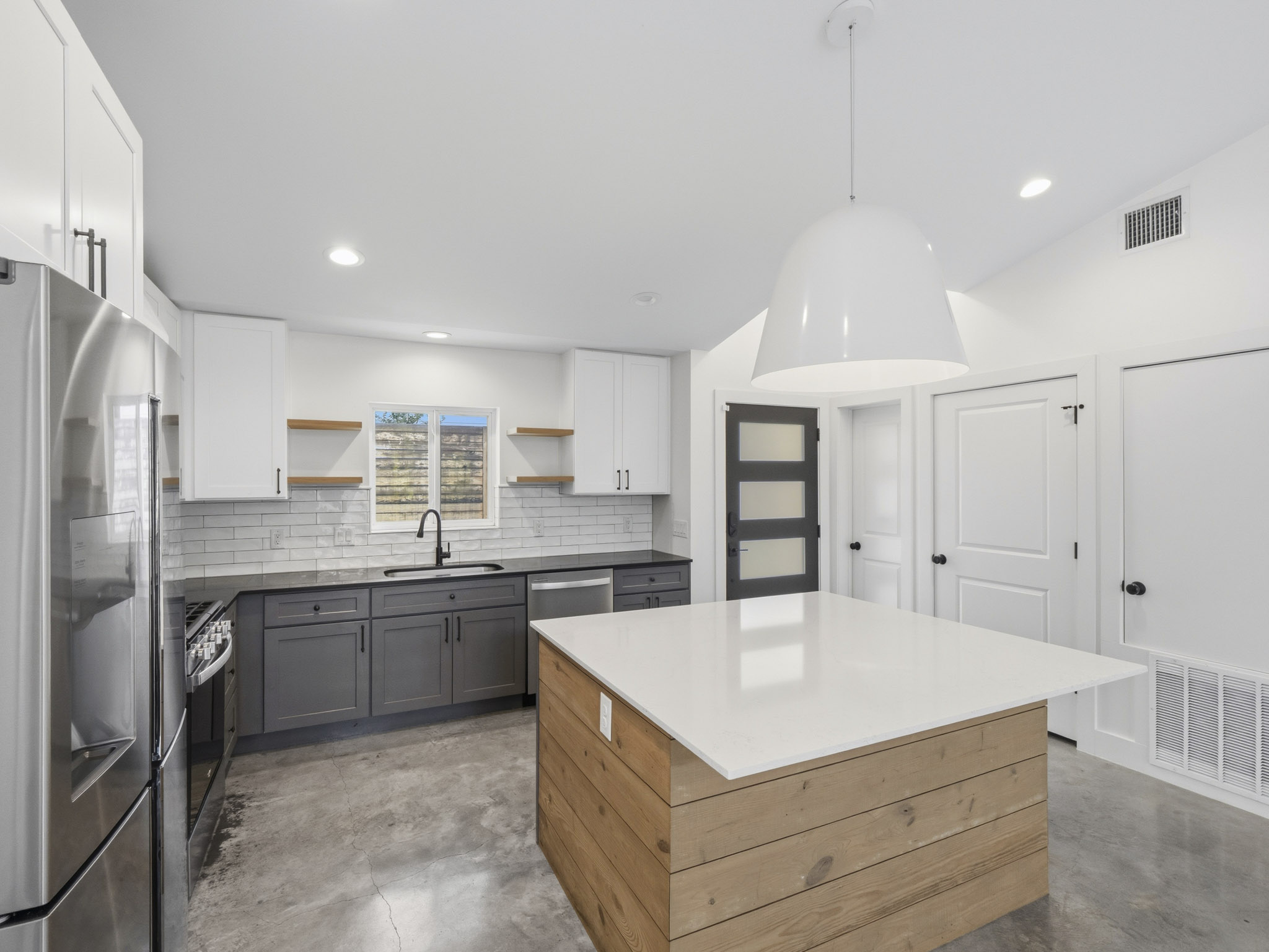 5005 Lott Avenue, Unit 2 Austin, TX 78721 - Photo 22 of 25 A sleek modern kitchen with contrasting cabinetry and a large central island provides functional elegance.