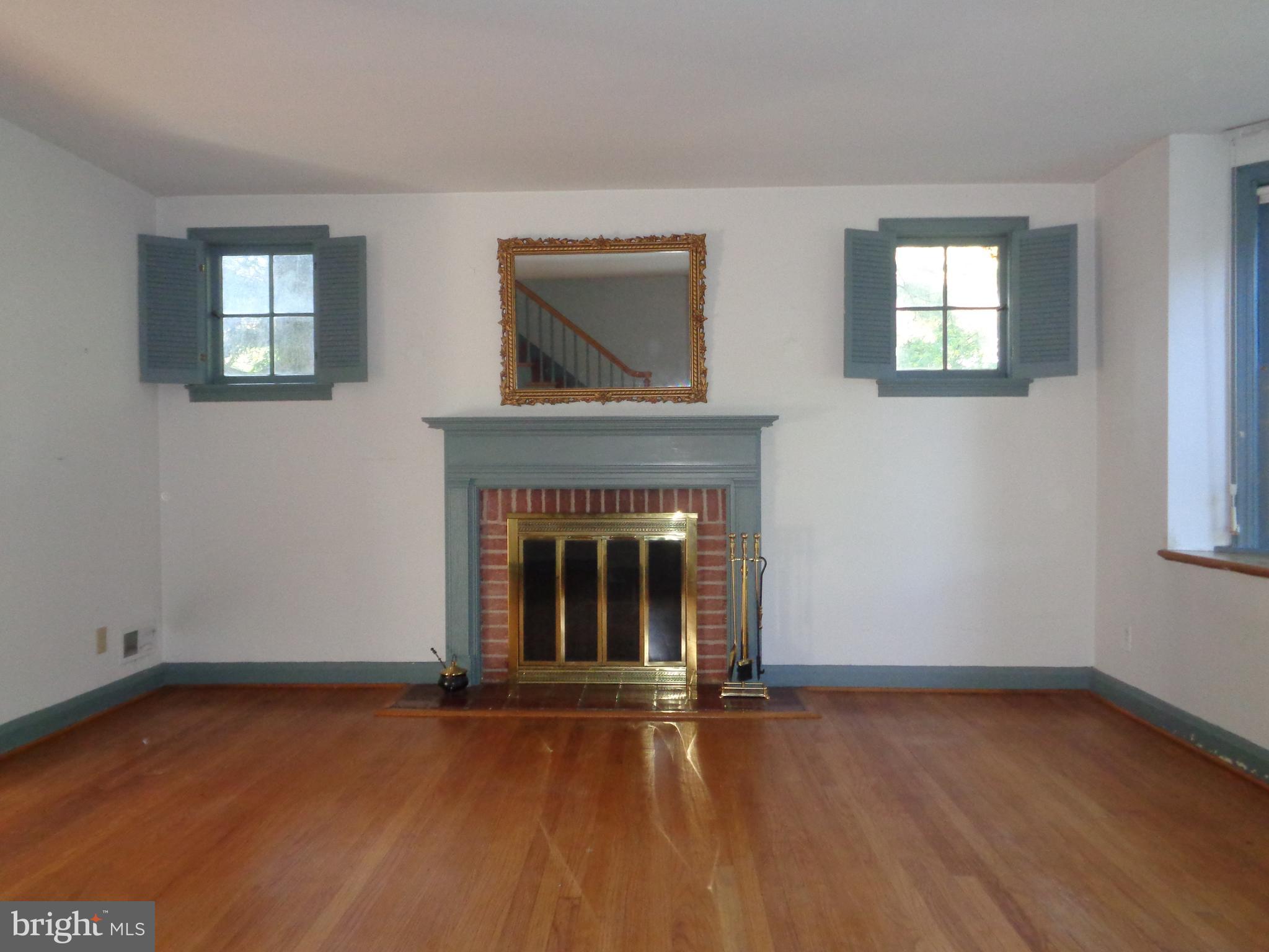 248 Gaywood Road Baltimore, MD 21212 - Photo 4 of 25 a view of an empty room with wooden floor fireplace and a window
