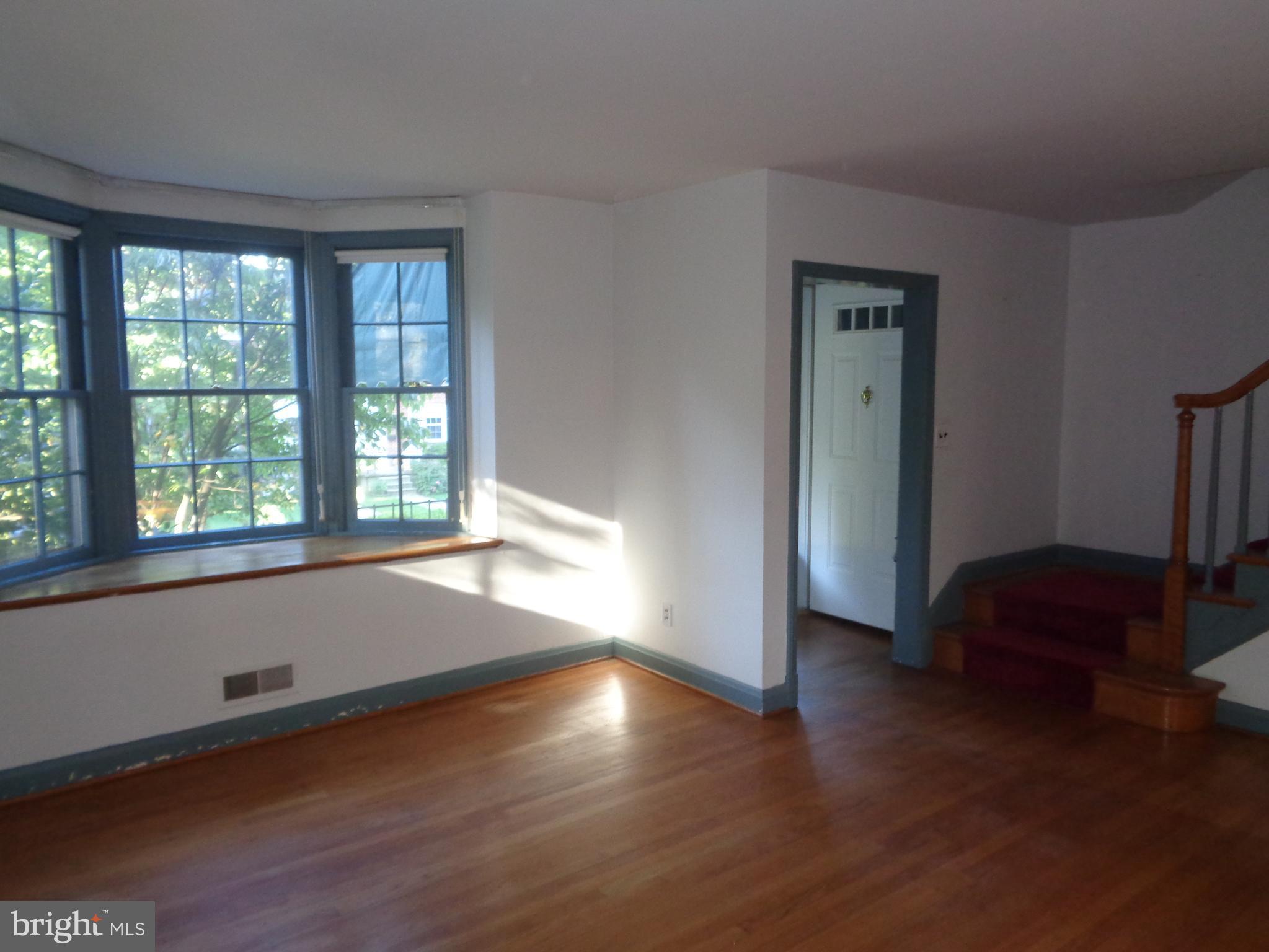 248 Gaywood Road Baltimore, MD 21212 - Photo 5 of 25 a view of an empty room with wooden floor and a window