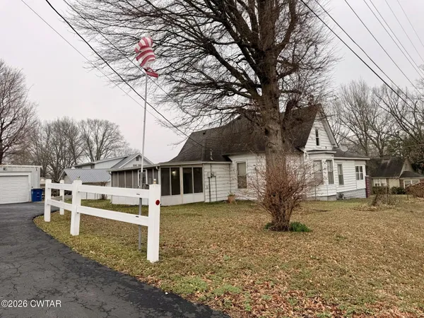 a front view of a house with a tree