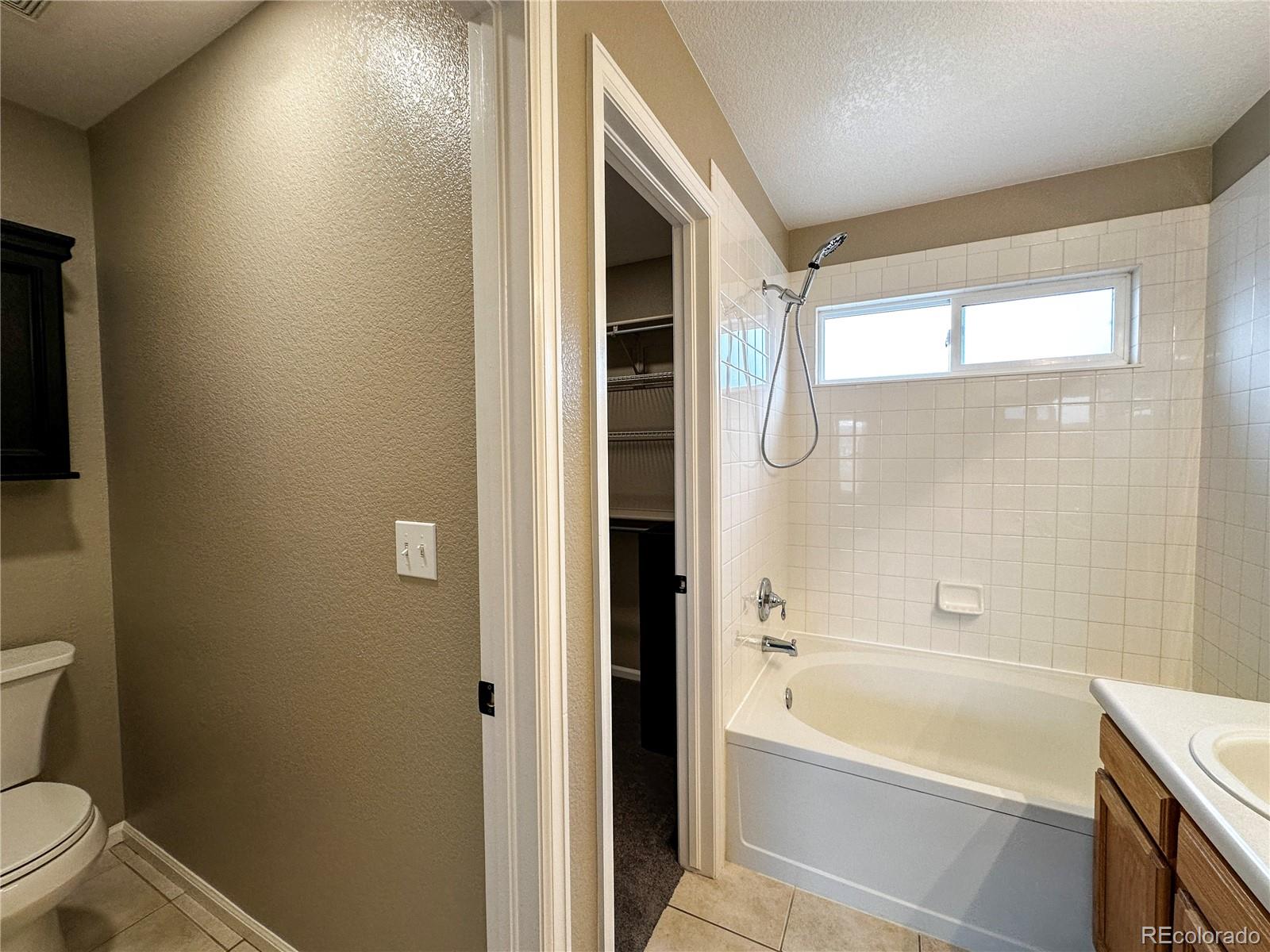 9933 Harris Street Denver, CO 80229 - Photo 17 of 25 a bathroom with a granite countertop bathtub shower sink vanity and toilet