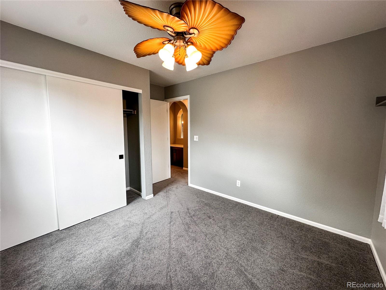 9933 Harris Street Denver, CO 80229 - Photo 19 of 25 an empty room with closet and chandelier fan
