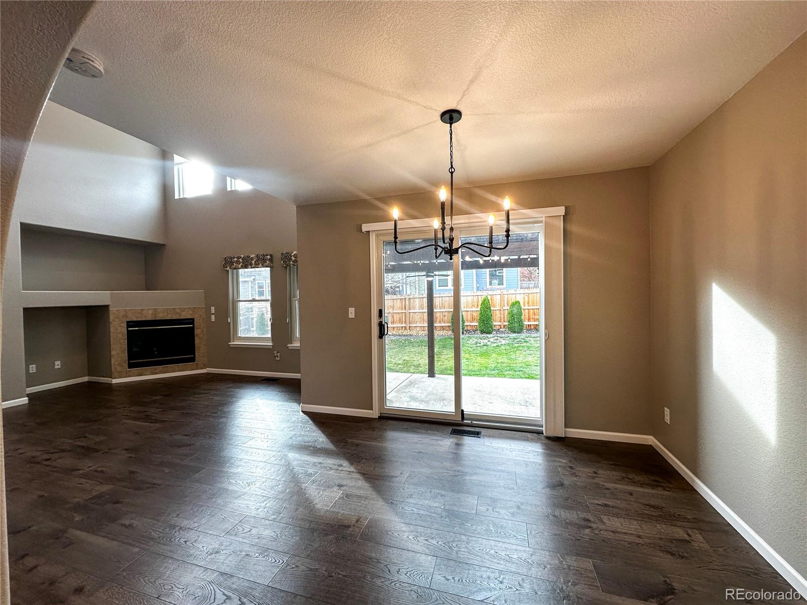 9933 Harris Street Denver, CO 80229 - Photo 5 of 25 a view of empty room with wooden floor and fireplace