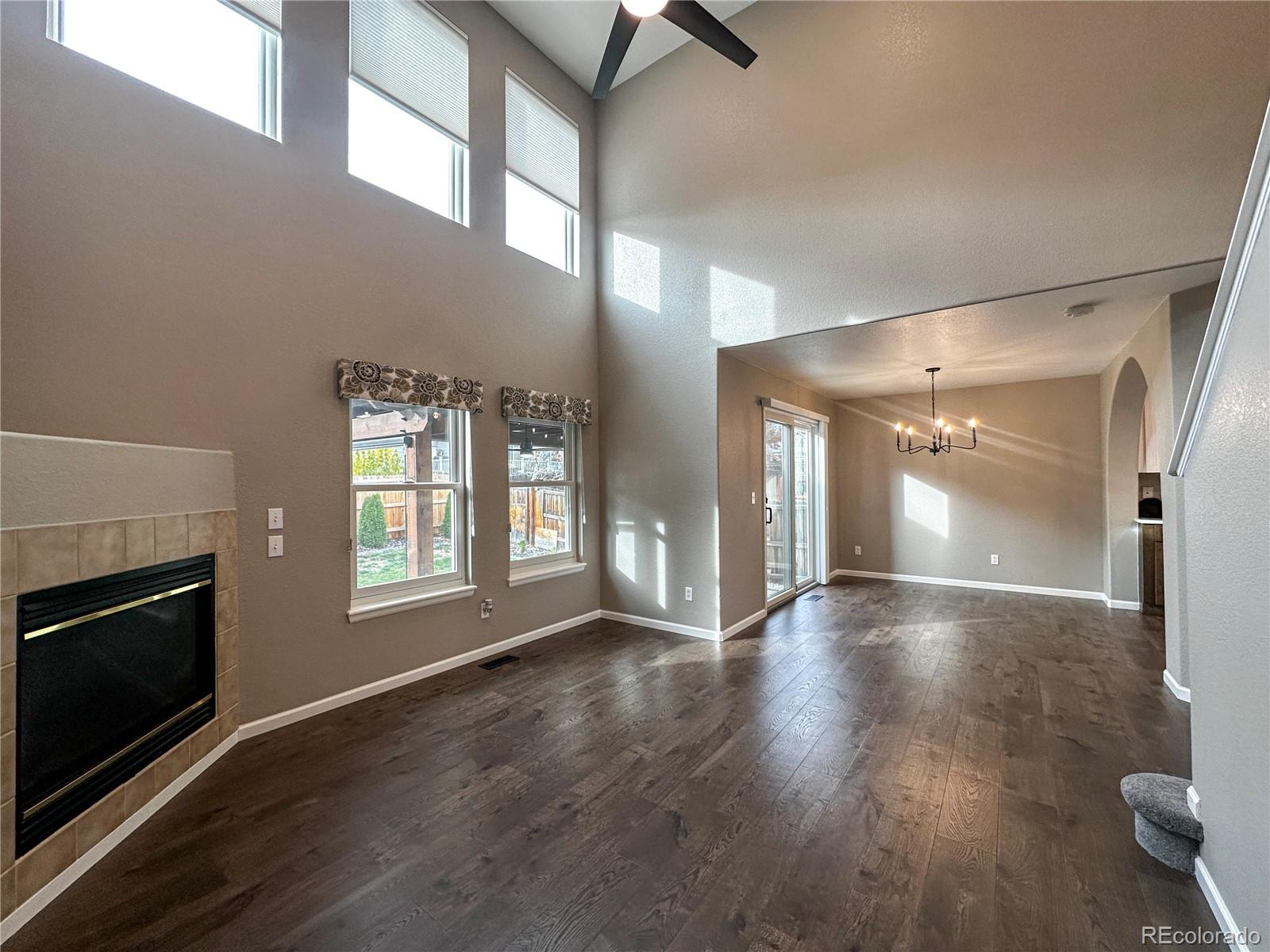 9933 Harris Street Denver, CO 80229 - Photo 6 of 25 a view of an empty room with wooden floor and a fireplace