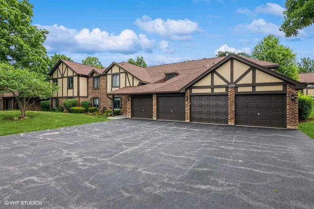 a view of a house with a yard and large tree