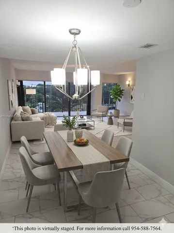 a dining room with furniture a chandelier and window