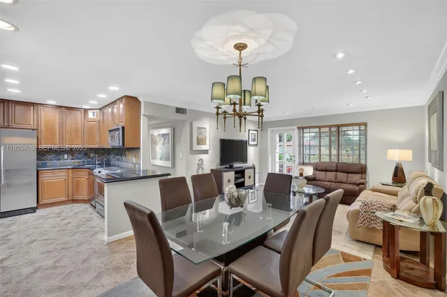 a view of a dining room with furniture a chandelier and wooden floor