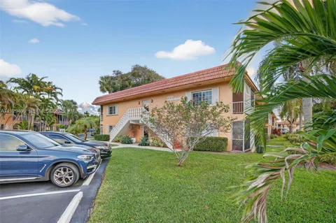 a view of a park with potted plants and large trees