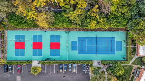 a view of a hallway with wooden floor and a bathroom