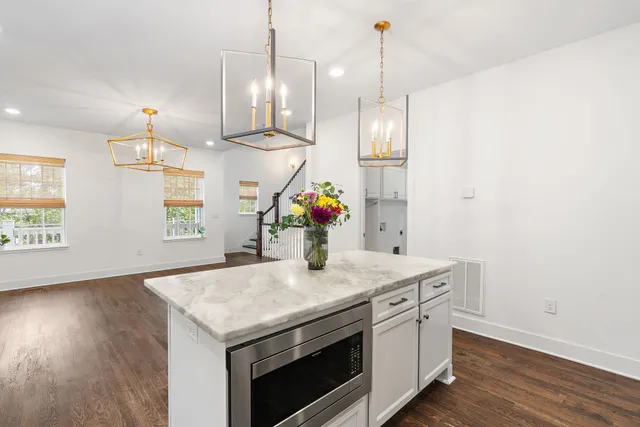 a kitchen with a stove and wooden floor