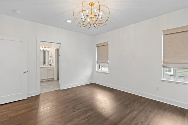 an empty room with wooden floor and a window