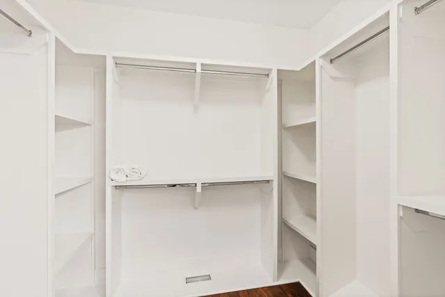 a view of walk in closet with empty racks