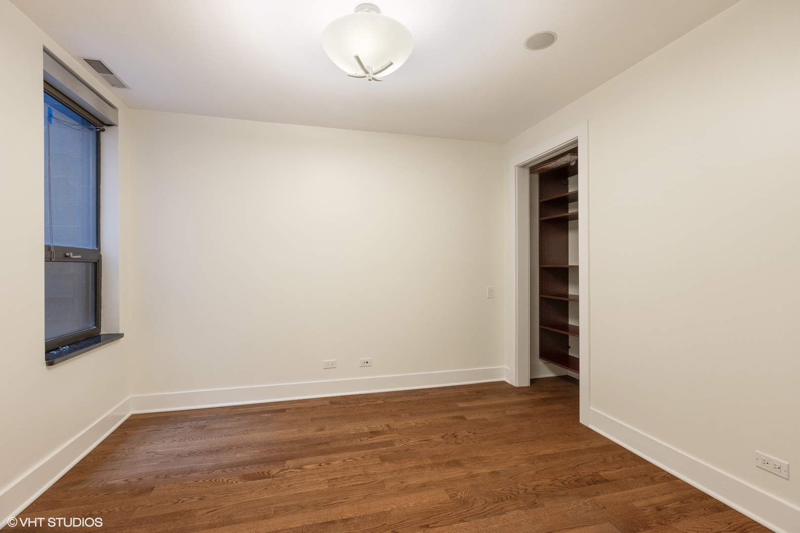 3310 North Halsted Street, Unit 2 Chicago, IL 60657 - Photo 15 of 22 an empty room with wooden floor and windows