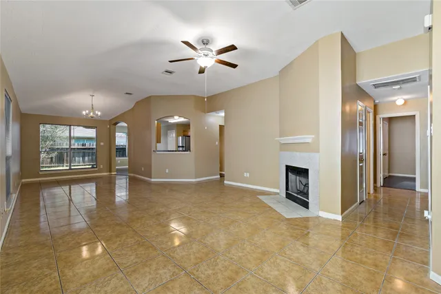 a view of an empty room with a fireplace and a window
