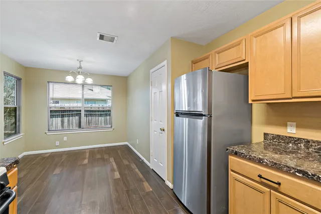 a kitchen with stainless steel appliances granite countertop a refrigerator and a stove top oven