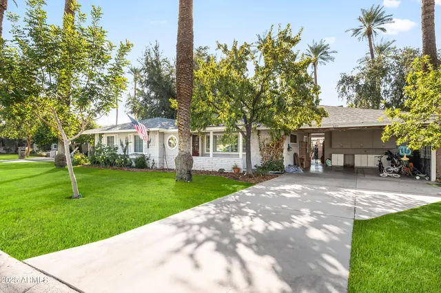 a front view of a house with a garden and trees