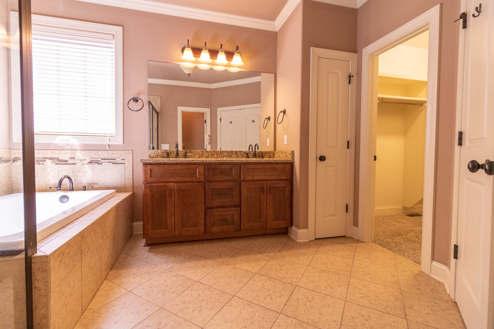 3075 Sakari Circle Spring Hill, TN 37174 - Photo 13 of 35 a bathroom with a tub a sink and mirrors