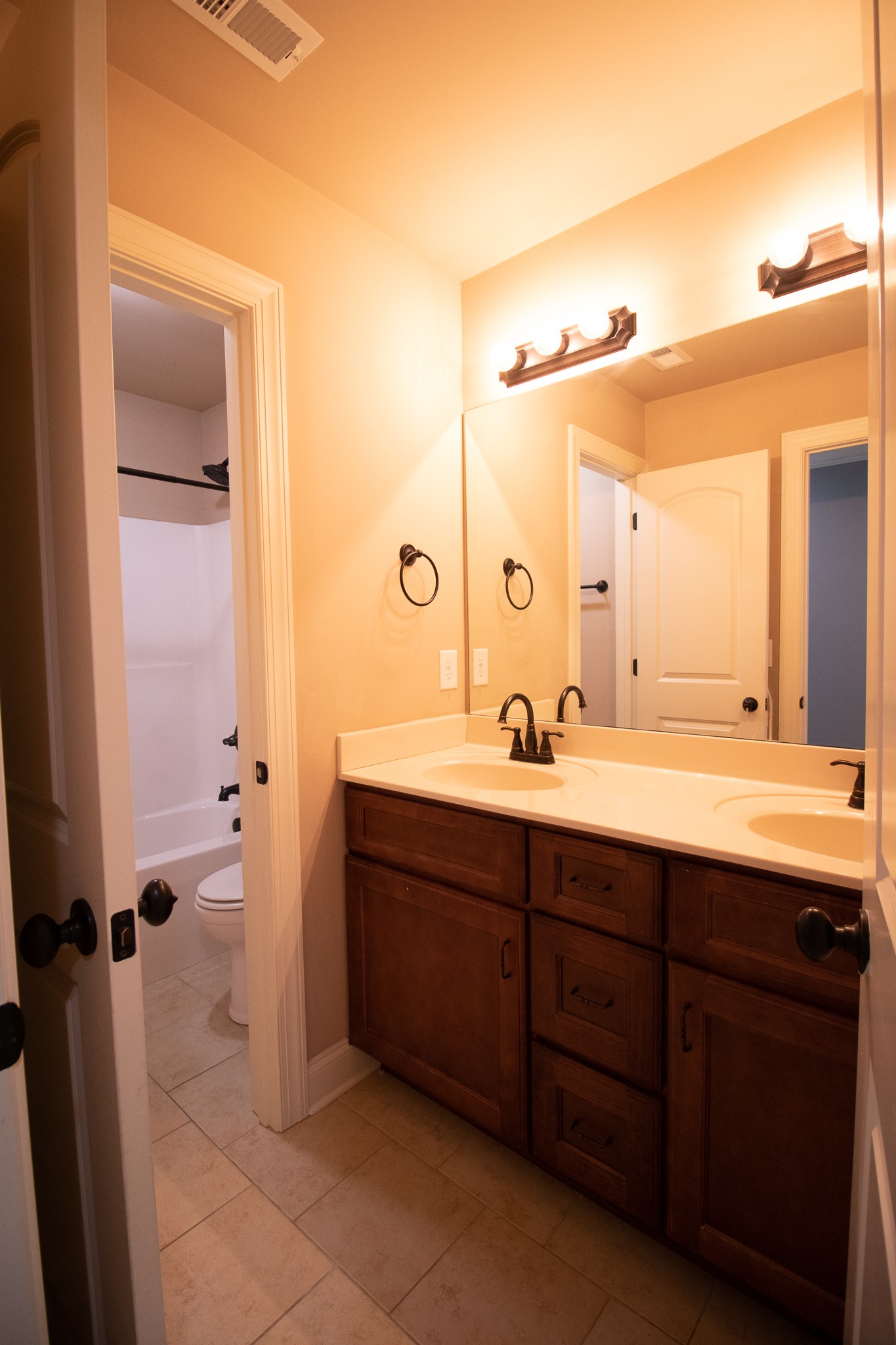 3075 Sakari Circle Spring Hill, TN 37174 - Photo 21 of 35 a bathroom with a double vanity sink and mirror with shower