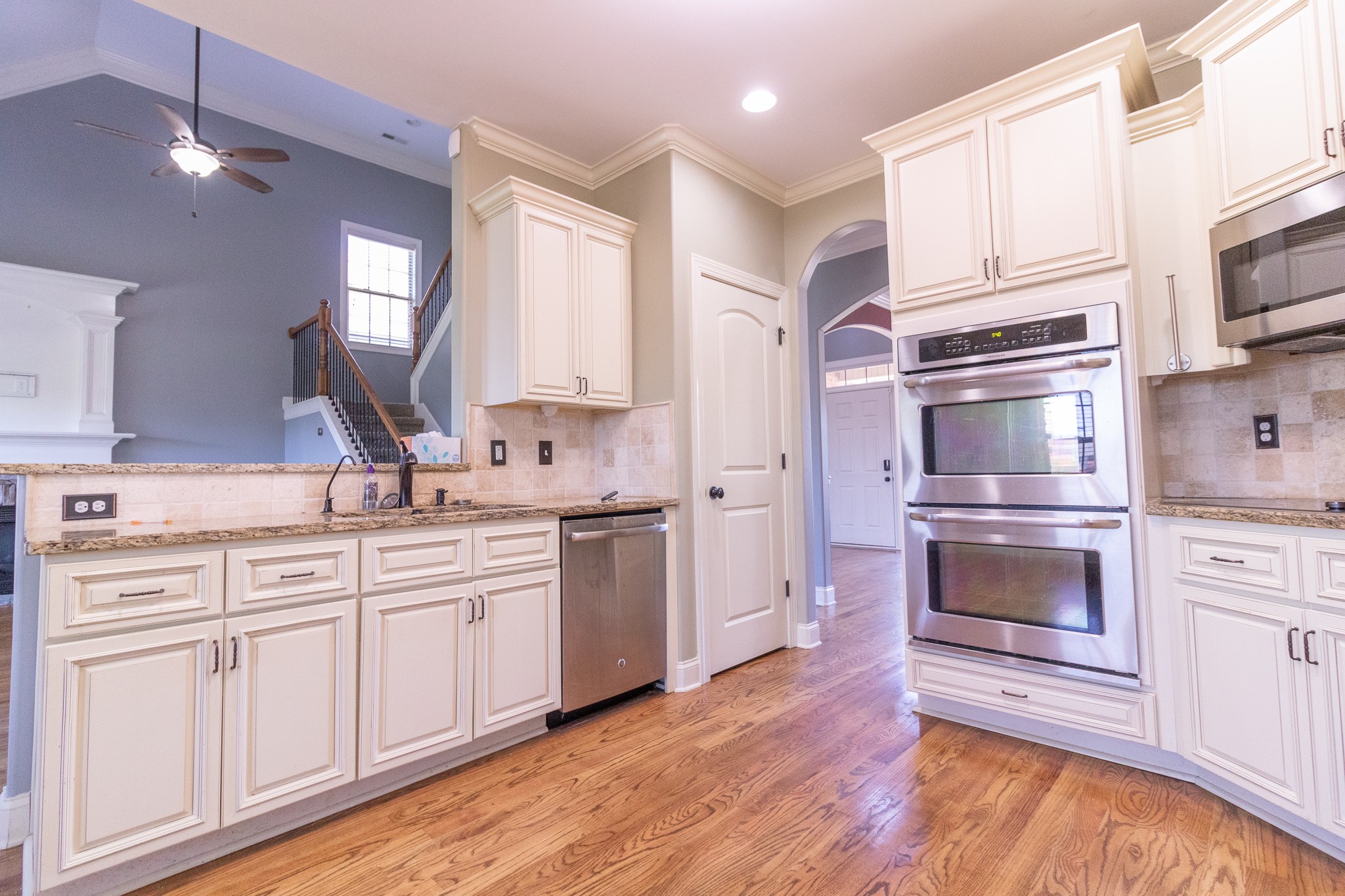 3075 Sakari Circle Spring Hill, TN 37174 - Photo 6 of 35 a kitchen with stainless steel appliances white cabinets and a wooden floor