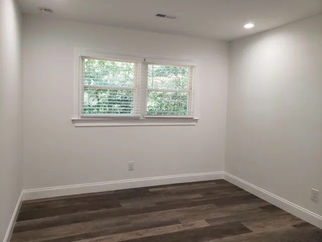 a view of a room with wooden floor and window