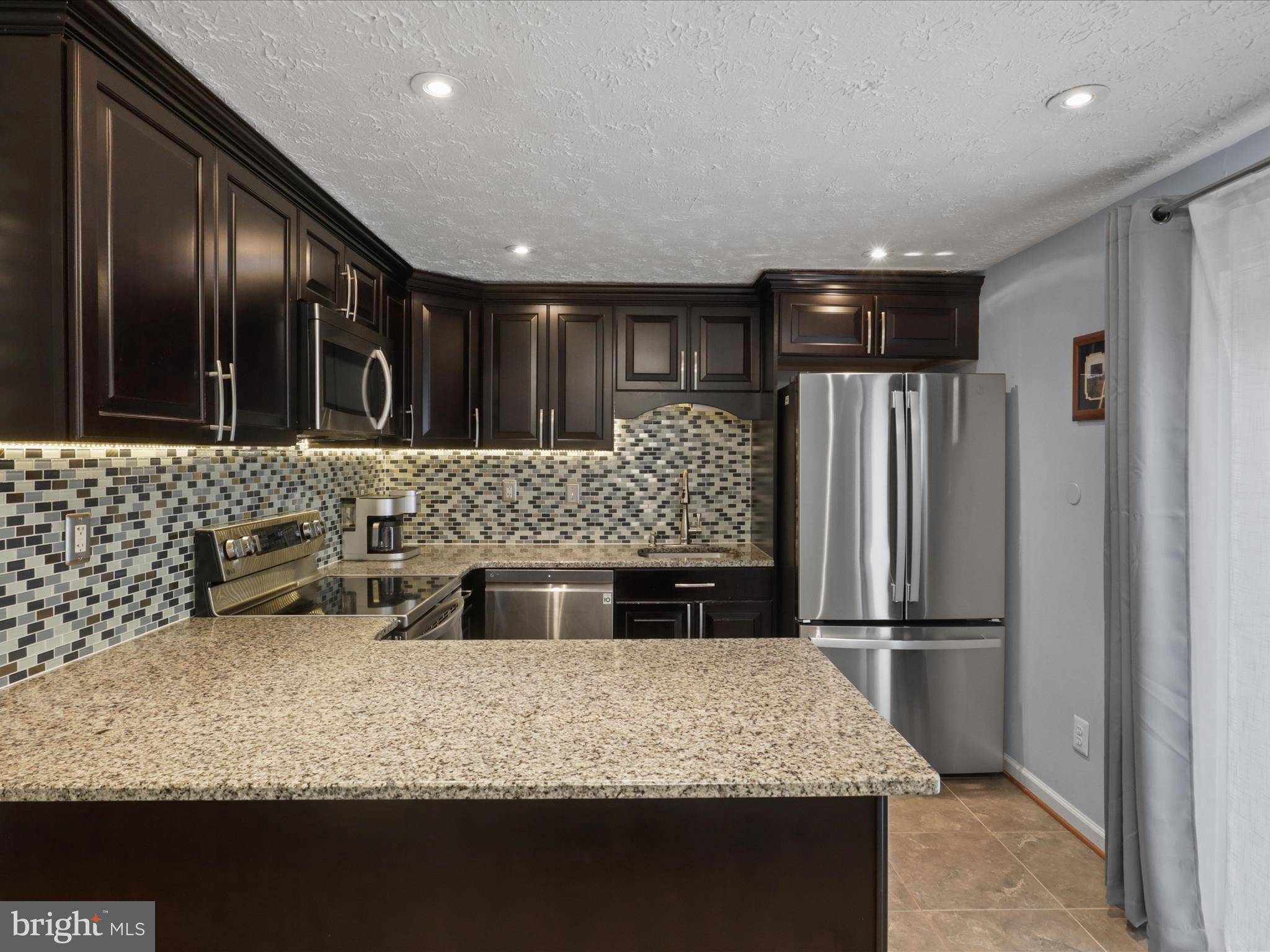7313 Husky Lane Springfield, VA 22151 - Photo 13 of 49 a kitchen with granite countertop stainless steel appliances a refrigerator and a sink