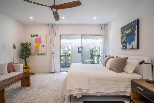 a bedroom with two beds and a ceiling fan