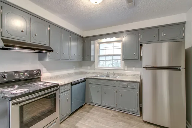 a kitchen with a stove sink and refrigerator