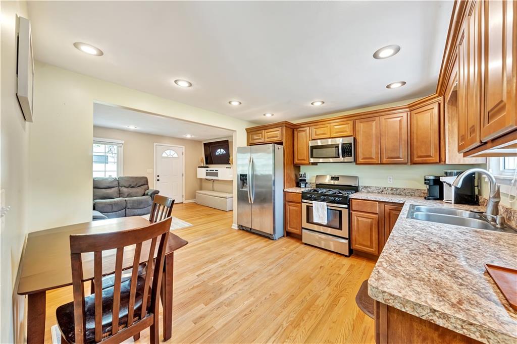 1248 Savannah Road New Castle, PA 16101 - Photo 4 of 25 a kitchen with stainless steel appliances granite countertop a refrigerator a stove top oven a sink dishwasher and white cabinets with wooden floor