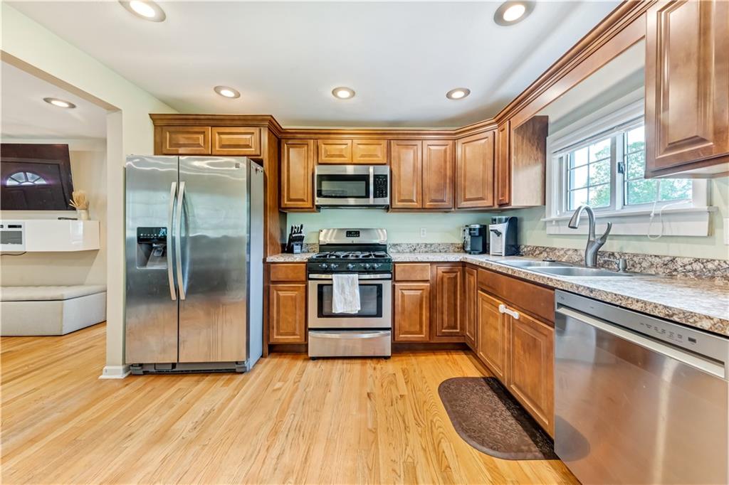 1248 Savannah Road New Castle, PA 16101 - Photo 5 of 25 a kitchen with stainless steel appliances granite countertop a refrigerator a sink dishwasher a stove with wooden cabinets and floor