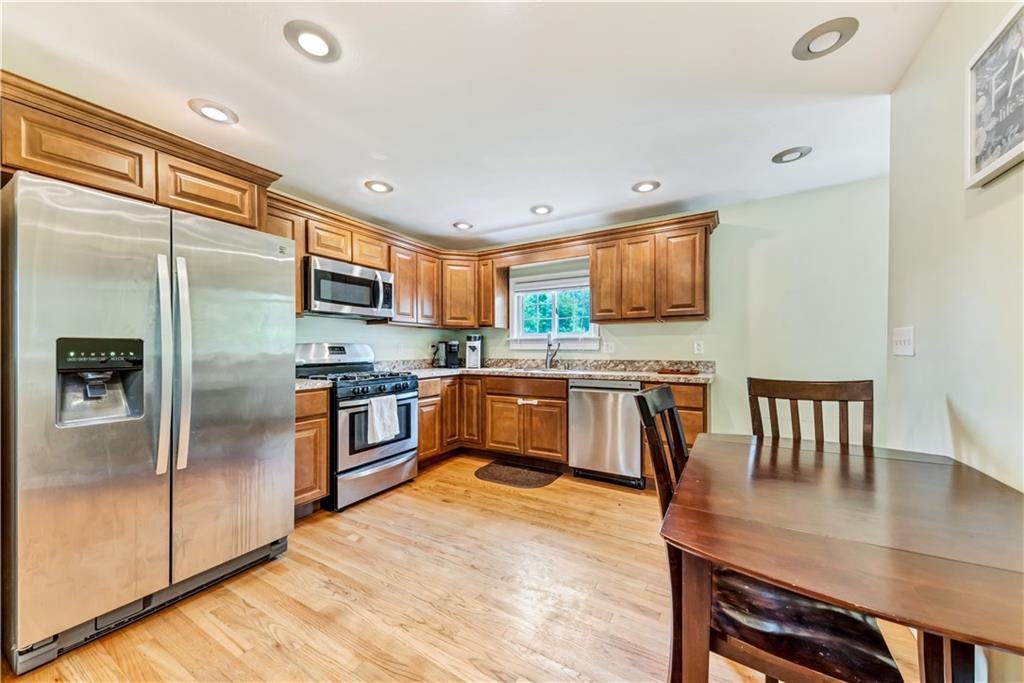 1248 Savannah Road New Castle, PA 16101 - Photo 6 of 25 a kitchen with stainless steel appliances granite countertop a refrigerator a stove a sink a dining table and chairs