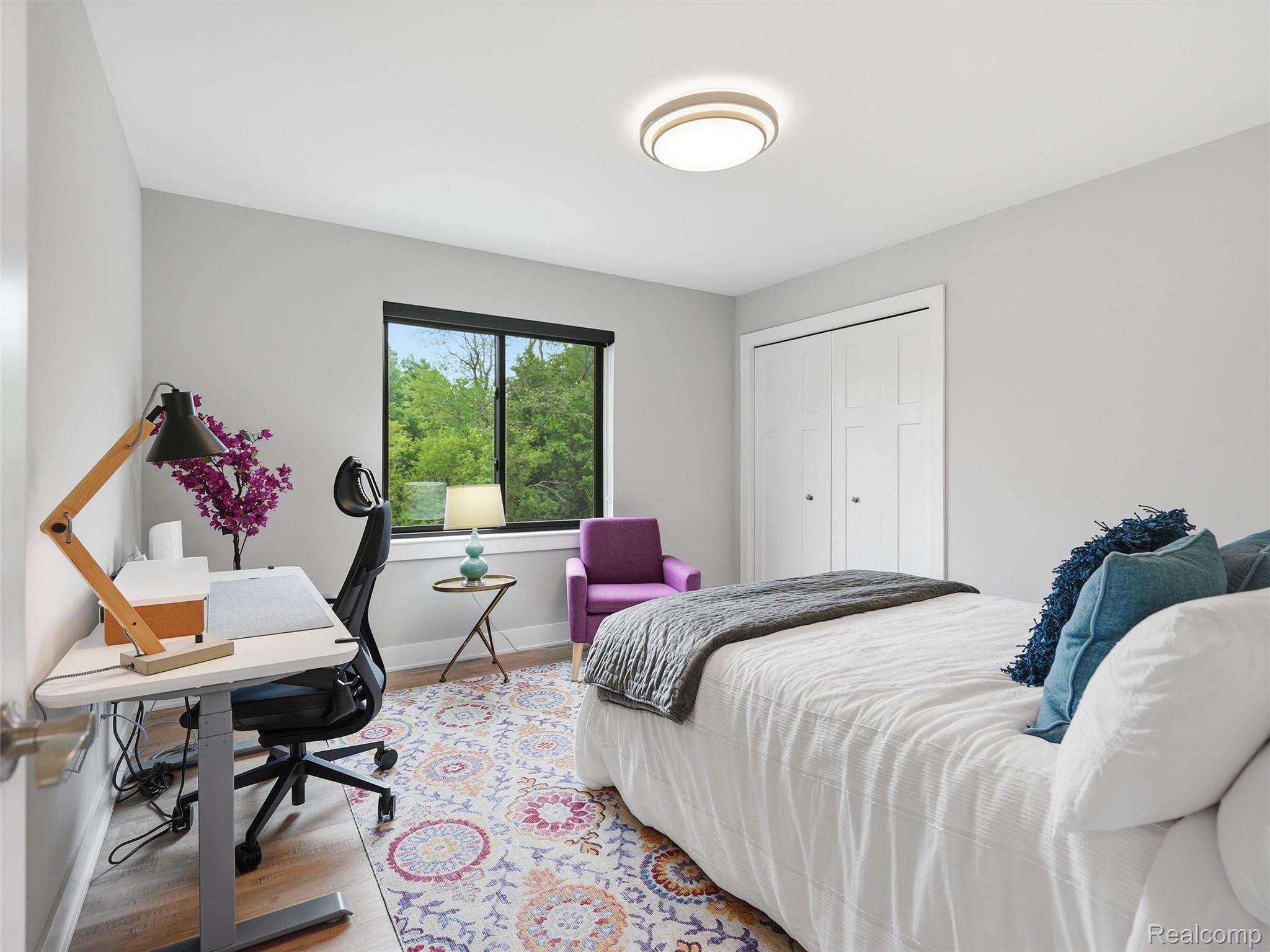 3007 28 Mile Road Washington, MI 48094 - Photo 32 of 69 Light-filled room featuring wood-finish flooring, a window with exterior greenery, and a flush-mount ceiling light