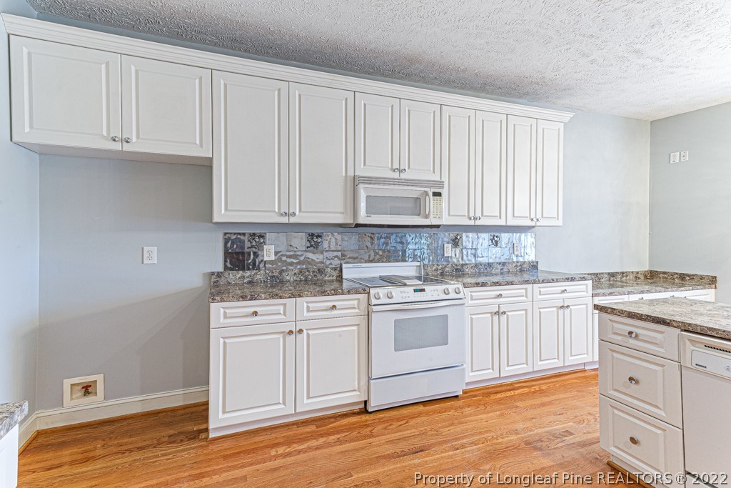 4051 Mt Tabor Road Red Springs, NC 28377 - Photo 16 of 50 a kitchen with granite countertop white cabinets and white appliances